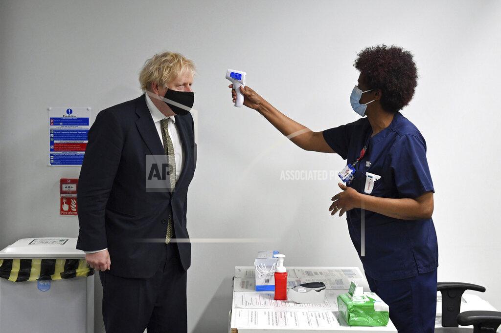 Stefan Rousseau Britain's Prime Minister Boris Johnson has his temperature checked during a visit to Chase Farm Hospital in north London, Monday Jan. 4, 2021. Johnson warned Sunday that more onerous lockdown restrictions in England are likely in the coming weeks as the country reels from a coronavirus variant that has pushed infection rates to their highest recorded levels. (Stefan Rousseau/Pool Photo via AP)