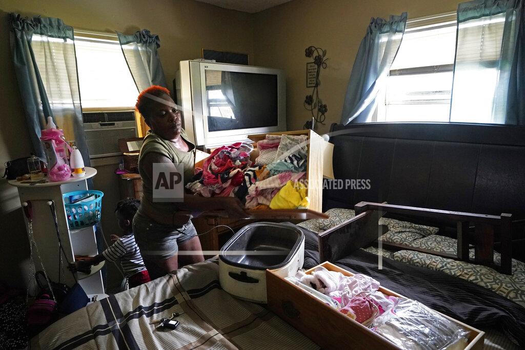 Gerald Herbert Patricia Mingo Lavergne salvages baby clothes she had been collecting for her unborn granddaughter, as she returns to her damaged home for the first time in Lake Charles, La., in the aftermath of Hurricane Laura, Sunday, Aug. 30, 2020. (AP Photo/Gerald Herbert)