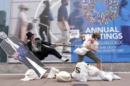 Activists holding a cardboard cutouts of Australian Prime Minister Scott Morrison protest outside of the International Monetary Fund headquarters during the World Bank/IMF Annual Meetings in Washington, Wednesday, Oct. 13, 2021. (AP Photo/Jose Luis Magana)