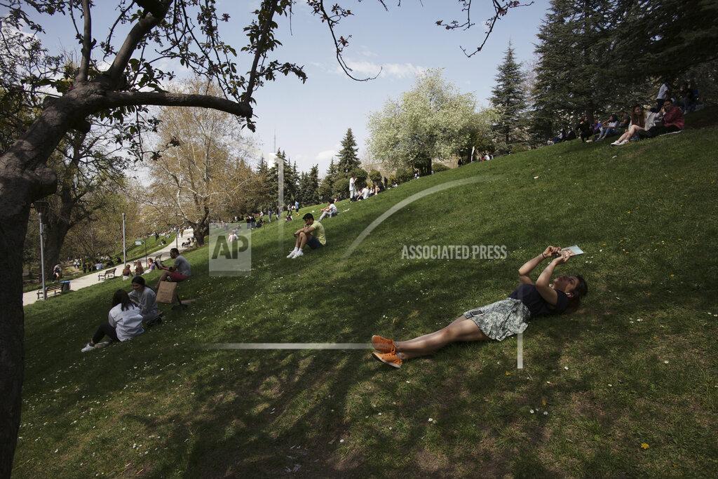 Burhan Ozbilici A woman reads a book as people sit in a park in Ankara, Turkey, Thursday, April 29, 2021, just hours before the start of a three-week full lockdown. People stocked up on groceries, shoppers filled markets and many left cities for their hometowns or the southern coast as Turkey's strictest COVID-19 lockdown yet comes into effect later on Thursday. President Recep Tayyip Erdogan imposed a "full lockdown" from Thursday evening until May 17 amid soaring COVID-19 infections and deaths. Turkey now ranks among the world's worst-hit countries.(AP Photo/Burhan Ozbilici)