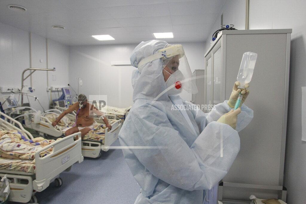 Roman Yarovitcyn A medical worker prepares to treat a patient infected with COVID-19 at the intensive care unit of a hospital in Nizhny Novgorod, Russia, Monday, Dec. 21, 2020. Russia has reported 29,350 new coronavirus cases, the country's biggest daily surge. Russia's total of over 2.8 million confirmed cases remains the fourth largest in the world. The state coronavirus task force has also reported over 51,000 deaths. (AP Photo/Roman Yarovitcyn)