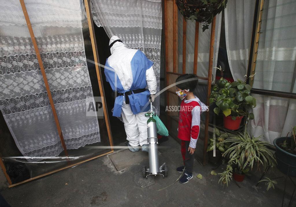 Marco Ugarte City worker Carlos Ruiz delivers a tank of oxygen to a COVID-19 patient, in the Iztapalapa borough of Mexico City, Friday, Jan. 15, 2021. The city offers free oxygen refills for COVID-19 patients. (AP Photo/Marco Ugarte)