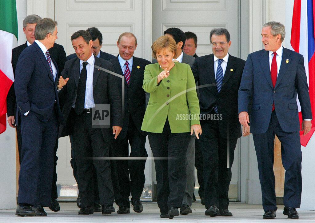 Michael Probst FILE - In this Thursday, June 7, 2007 file photo, German Chancellor Angela Merkel, center, U.S. President George Bush, Italian Premier Romano Prodi, Japanese Premier Shinzo Abe, Russian President Vladimir Putin, French President Nicolas Sarkozy, EU Commission President Jose Manuel Barroso, British Premier Tony Blair and Canadian Premier Stephen Harper walk to their family photo during the G8 summit in Heiligendamm, Germany. Merkel has also been lauded as an impressive role model for girls both at home and around the globe for standing up to male leaders. (AP Photo/Michael Probst, File)