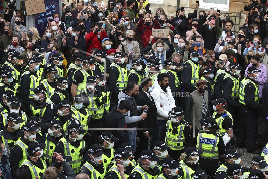 Andrew Milligan Two men stand surrounded by police and protesters, after being released from an Immigration Enforcement police van accompanied by lawyer Aamer Anwar and Mohammad Asif, director of the Afghan Human Rights Foundation, in Glasgow, Scotland, Thursday May 13, 2021. Some hundreds of protesters blockaded the street in Glasgow on Thursday in a seven-hour standoff which successfully forced the release of two men detained by U.K. immigration authorities. (Andrew Milligan/PA via AP)