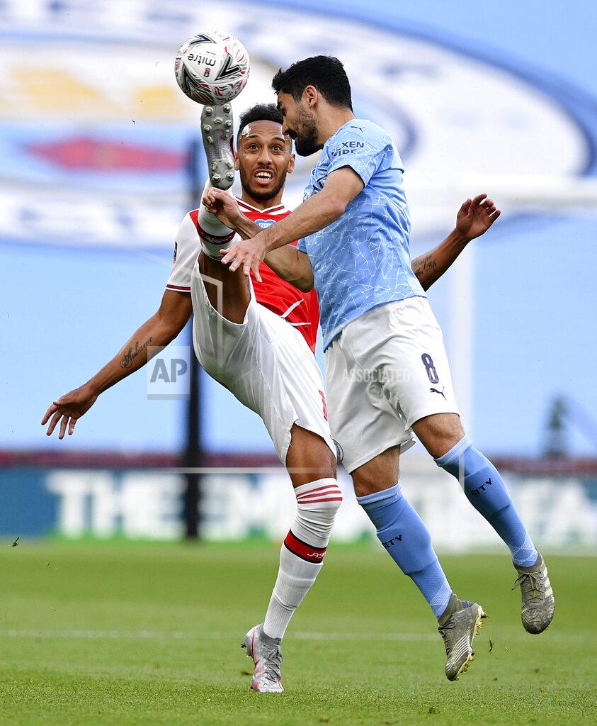 Justin Tallis Arsenal's Pierre-Emerick Aubameyang, left, kicks the ball away from Manchester City's Ilkay Gundogan during the FA Cup semifinal soccer match between Arsenal and Manchester City at Wembley in London, England, Saturday, July 18, 2020. (AP Photo/Justin Tallis,Pool)