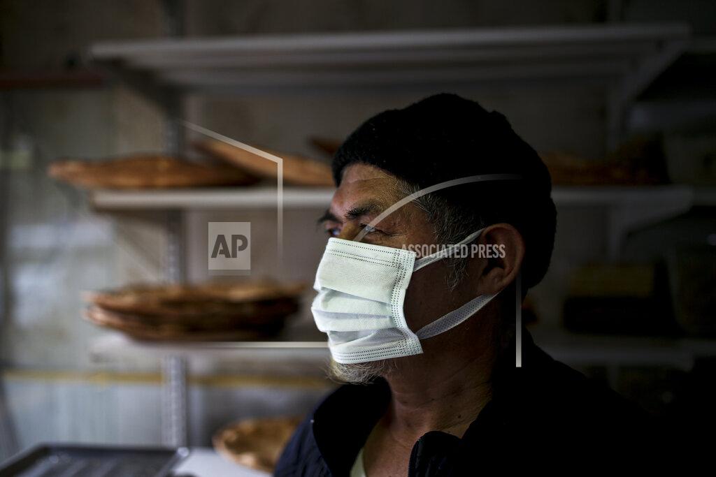 Emrah Gurel Muhammed Emin, a member of the Uighur community, looks outside in his bakery in Istanbul's Zeytinburnu neighborhood, Tuesday, Feb. 2, 2021. Because of shared cultural ties, Turkey has long been a safe haven for the Uighurs, a Turkic group native to China's far west Xinjiang region. Opposition legislators in Turkey are accusing Ankara's leaders of secretly selling out Uighurs to China in exchange for coronavirus vaccines. (AP Photo/Emrah Gurel)