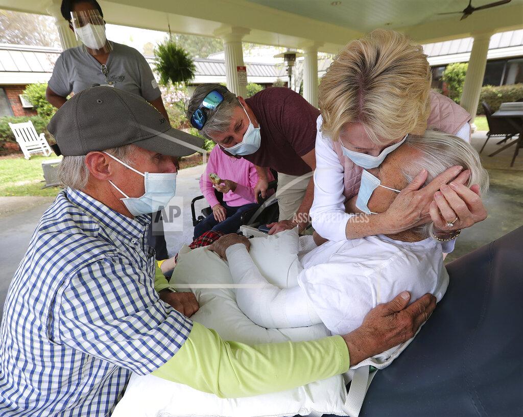Curtis Compton Bonnie McBrome, right, and her brother Erwin Bryan, left, emotionally embrace their father Doyle Bryan, 86, for the first time since COVID restrictions were put in place as loved ones begin in person family visits at Westbury Medical Care and Rehab on Tuesday, March 30, 2021, in Jackson, Ga. Looking on at center is grandson Brian Abernathy. The facility was one of the hardest hit in Georgia losing 34 residents and 1 staff member to the pandemic. (Curtis Compton/Atlanta Journal-Constitution via AP)