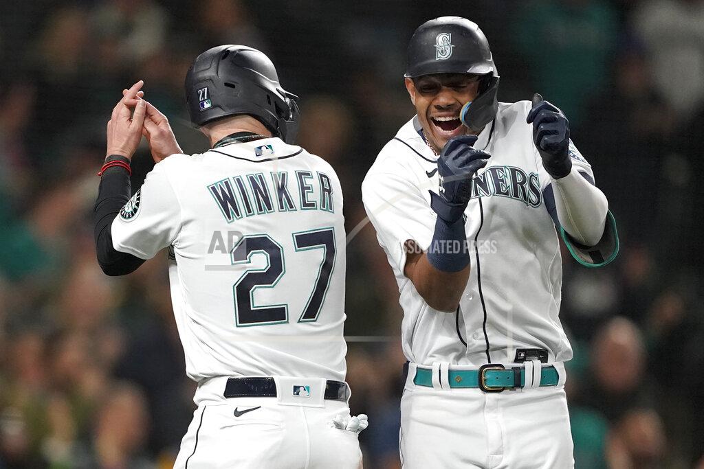 Ted S. Warren Seattle Mariners' Julio Rodriguez, right, celebrates with Jesse Winker (27) after hitting a two-run home run to score Winker against the Oakland Athletics during the fifth inning of a baseball game Tuesday, May 24, 2022, in Seattle. (AP Photo/Ted S. Warren)