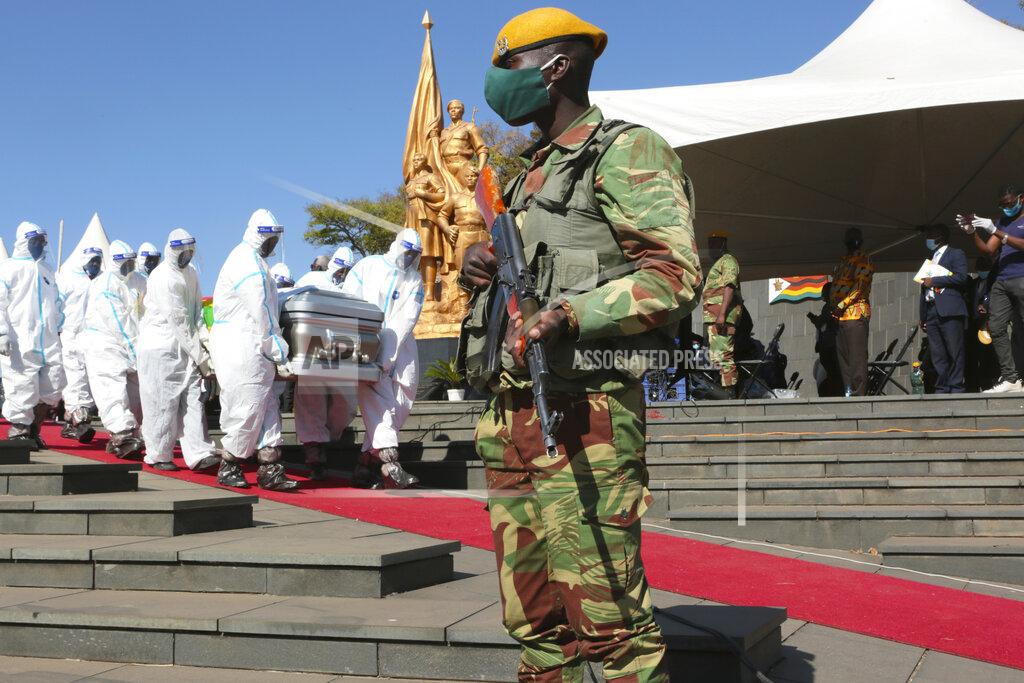 Tsvangirayi Mukwazhi An armed soldier stands guard during the burial of a Zimbabwean minister Perence Shiri, who died of Covid-19, in Harare, Friday, July, 31, 2020. Zimbabwe's capital, Harare, was deserted Friday, as security agents vigorously enforced the country's lockdown amidst planned protests.(AP Photo/Tsvangirayi Mukwazhi)