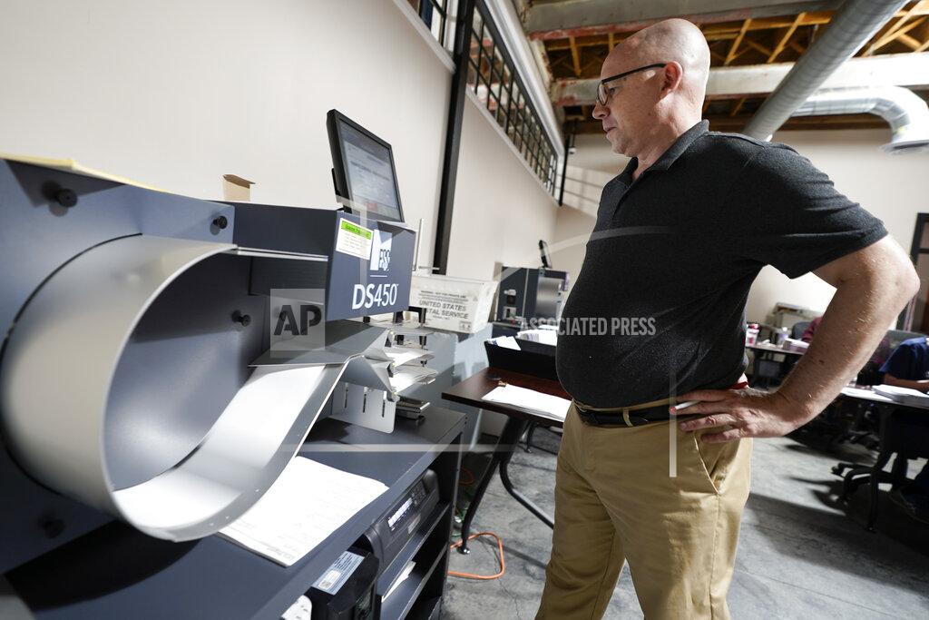 Keith Srakocic Mercer County Director of Elections, Thad Hall uses the optical scanner to continue counting ballots for the Pennsylvania primary election, Wednesday, May 18, 2022, in Mercer, Pa.. Vote counting continues as Republican candidates Dr. Mehmet Oz and David McCormick are locked in a too-early-to-call race for Pennsylvania's hotly contested Republican nomination for an open U.S. Senate seat. (AP Photo/Keith Srakocic)