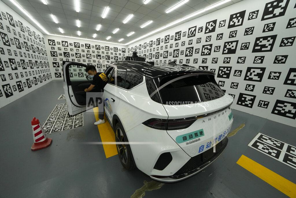 Ng Han Guan A driver leaves a car after parking it in a chamber used to calibrate the self-driving taxi developed by tech giant Baidu Inc. on June 14, 2022, in Beijing. Baidu Inc. is China's highest-profile competitor in a multibillion-dollar race with Alphabet Inc.'s Waymo and General Motors Co.'s Cruise to create self-driving cars. (AP Photo/Ng Han Guan)