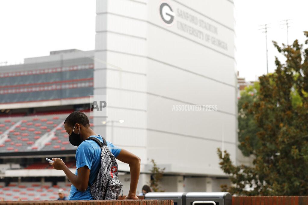 Joshua L. Jones A University of Georgia student waits for the bus outside the University's Tate Student Center in Athens, Ga, on Wednesday, Sept. 16, 2020. Colleges across the country are struggling to salvage the fall semester as campus coronavirus cases skyrocket and tensions with local health leaders flare. Schools have locked down dorms, imposed mask mandates, barred student fans from football games and toggled between online and in-person classes. (Joshua L. Jones/Athens Banner-Herald via AP)