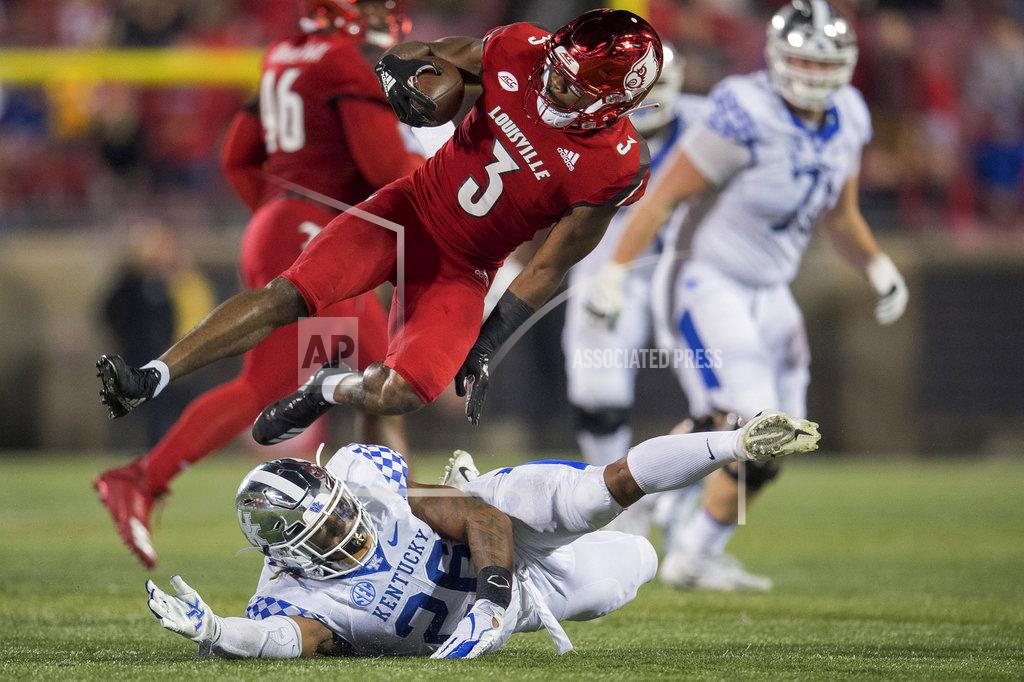 Bryan Woolston After making an interception, Louisville cornerback Cornelius Sturghill (3) avoids the tackle of Kentucky running back Benny Snell Jr. (26) during the second half of an NCAA college football game in Louisville, Ky., Saturday, Nov. 24, 2018. (AP Photo/Bryan Woolston)