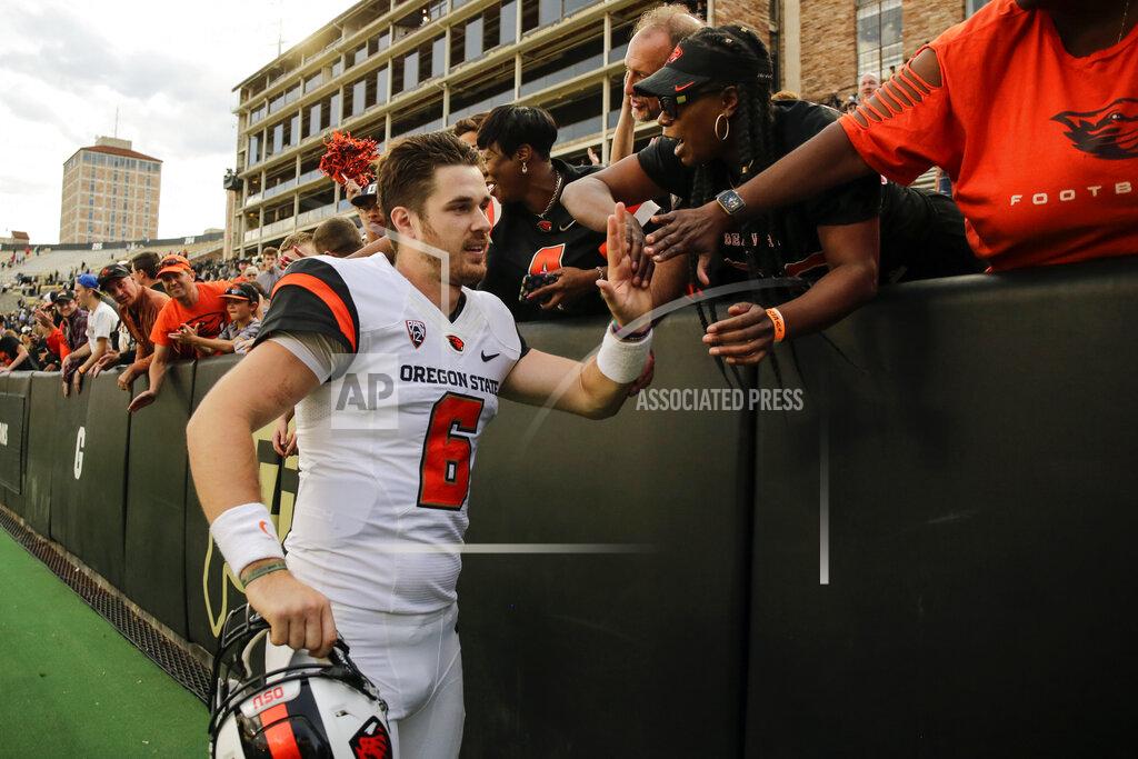 FILE - In this Oct. 27, 2018, file photo, Oregon State quarterback Jake Luton high fives fans after the team's overtime win against Colorado in an NCAA football game, in Boulder, Colo. Jake Luton is determined to make the most of his last chance. After a career marred by injury, he was granted a sixth season of eligibility. (AP Photo/Jack Dempsey, File)