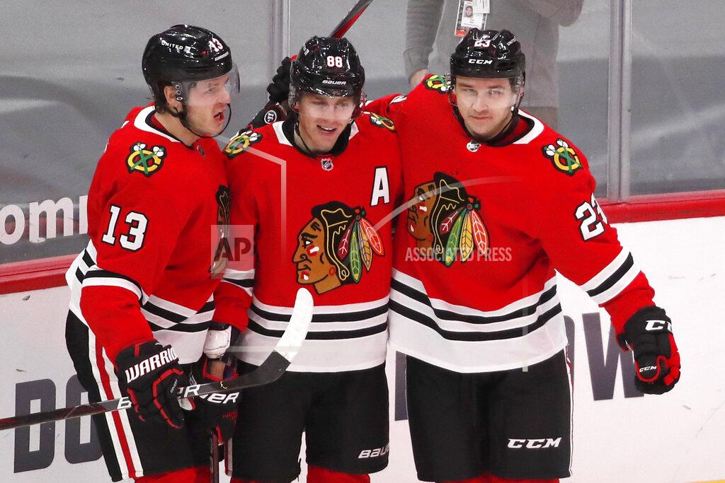 Jeff Haynes Chicago Blackhawks right wing Patrick Kane, center, celebrates with teammates Mattias Janmark, left, and Philipp Kurashev, right, after scoring a goal against the Columbus Blue Jackets during the third period of an NHL hockey game Sunday, Jan. 31, 2021, in Chicago. (AP Photo/Jeff Haynes)