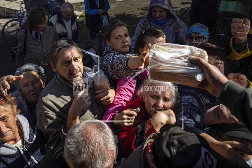 Evgeniy Maloletka Local residents receive humanitarian aid distributed by volunteers in the recently retaken area of Izium, Ukraine, Wednesday, Sept. 21, 2022. (AP Photo/Evgeniy Maloletka)