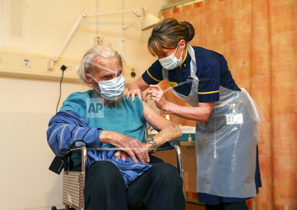 Steve Parsons 88-year-old Trevor Cowlett receives the Oxford University/AstraZeneca COVID-19 vaccine from nurse Sam Foster, at the Churchill Hospital in Oxford, England, Monday, Jan. 4, 2021, on the first day of rolling out the newly approved jab. (Steve Parsons/Pool Photo via AP)
