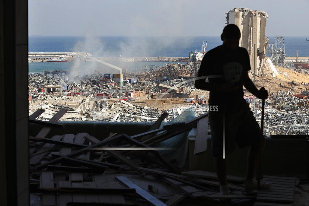 Hussein Malla A man stands in a damaged apartment as he looks out at the scene of a massive explosion that hit the seaport of Beirut, Lebanon, Wednesday, Aug. 5, 2020. Residents of Beirut awoke to a scene of utter devastation on Wednesday, a day after a massive explosion at the port sent shock waves across the Lebanese capital, killing at least 100 people and wounding thousands. (AP Photo/Hussein Malla)
