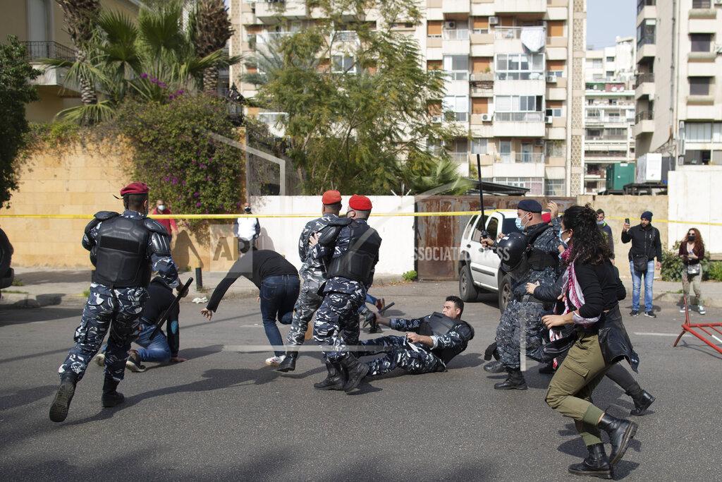 Hassan Ammar Riot police and army soldiers scuffle with anti-government protesters outside a military court in Beirut, Lebanon, Monday, Feb. 8, 2021. Riot police briefly clashed Monday in Beirut with hundreds of protesters demanding the release of anti-government activists detained following riots in northern Lebanon late last month. (AP Photo/Hassan Ammar)