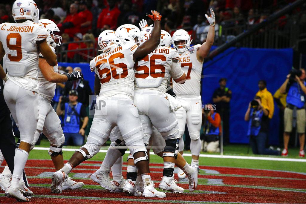 Butch Dill Texas players celebrate a touchdown carry by quarterback Sam Ehlinger, obscured, during the first half of the Sugar Bowl NCAA college football game against Georgia in New Orleans, Tuesday, Jan. 1, 2019. (AP Photo/Butch Dill)
