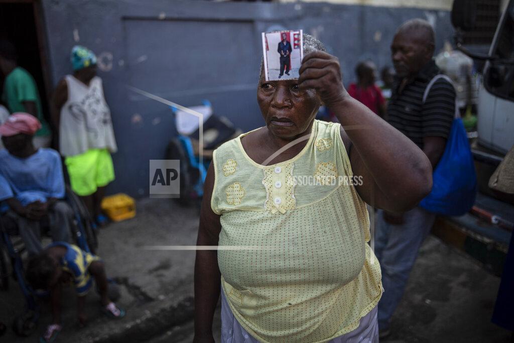 Rodrigo Abd Twice displaced due to the country's escalating violence, Marie Jaquesmal poses with a portrait of her son Michel, who went missing during an assault lead by police, in Port-au-Prince, Haiti, Thursday, Sept. 16, 2021. With 139 houses set fire behind her, she lost track of her 28-year-old son, who is deaf and cannot speak. "I don't know if he is dead or alive, the only thing I saw is that those men were policemen." (AP Photo/Rodrigo Abd)