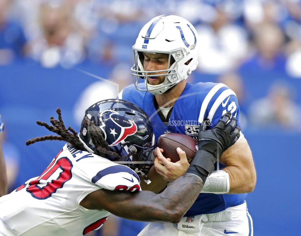Michael Conroy FILE - In this Sept. 30, 2018, file photo, Indianapolis Colts quarterback Andrew Luck (12) is sacked by Houston Texans' Jadeveon Clowney (90) during the first half of an NFL football game, in Indianapolis. Some juicy rematches highlight wild-card weekend, in which, well, just about any of the eight teams advancing wouldn't be a surprise. Seattle beat Dallas early this season, and Baltimore handled the Los Angeles Chargers late. The Colts and Texans split two games. Only the Eagles and Bears didn't face off. (AP Photo/Michael Conroy, File)