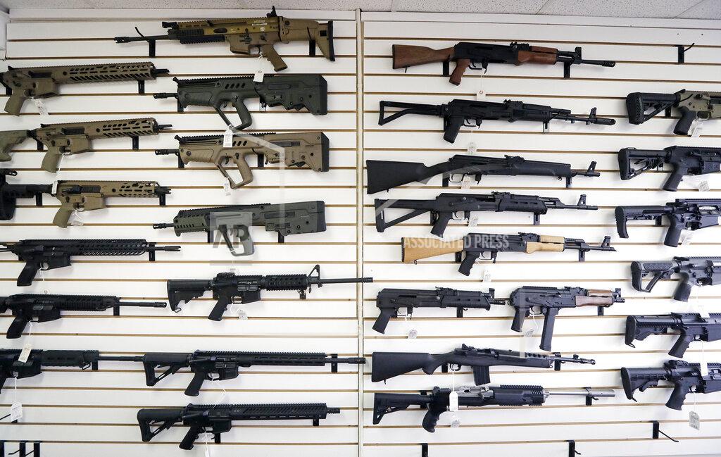 Elaine Thompson FILE - In this Oct. 2, 2018, file photo, semi-automatic rifles fill a wall at a gun shop in Lynnwood, Wash. With Democrats controlling the presidency and Congress, Republican state lawmakers concerned about the possibility of new federal gun control laws aren't waiting to react. Legislation in at least a dozen states seeks to nullify any new restrictions, such as ammunition limits or a ban on certain types of weapons. (AP Photo/Elaine Thompson, File)