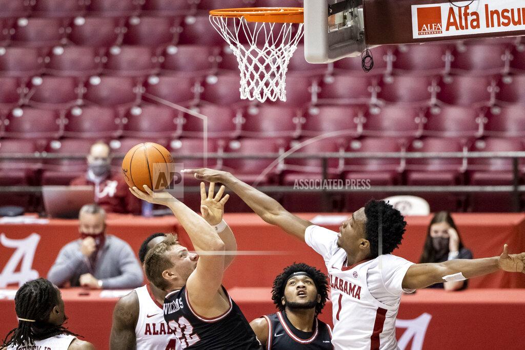 Vasha Hunt Western Kentucky forward Carson Williams (22) shots with Alabama forward/guard Herbert Jones (1) defending during the first half of an NCAA college basketball game, Saturday, Dec. 19, 2020, in Tuscaloosa, Ala. (AP Photo/Vasha Hunt)