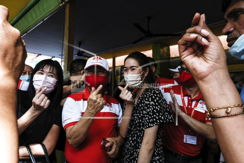 Ee Ming Toh Progress Singapore Party Secretary-General Dr Tan Cheng Bock, center left, wears a face mask while making a heart hand gesture with female supporters while campaigning outside a coffeeshop in Singapore on July 5, 2020. Singaporeans go to the polls on July 10 in Southeast Asia's first election since the coronavirus pandemic began, with the health crisis and an economic recession expected to bolster Prime Minister Lee Hsien Loong's party and extend its unbroken rule. (AP Photo/Ee Ming Toh)