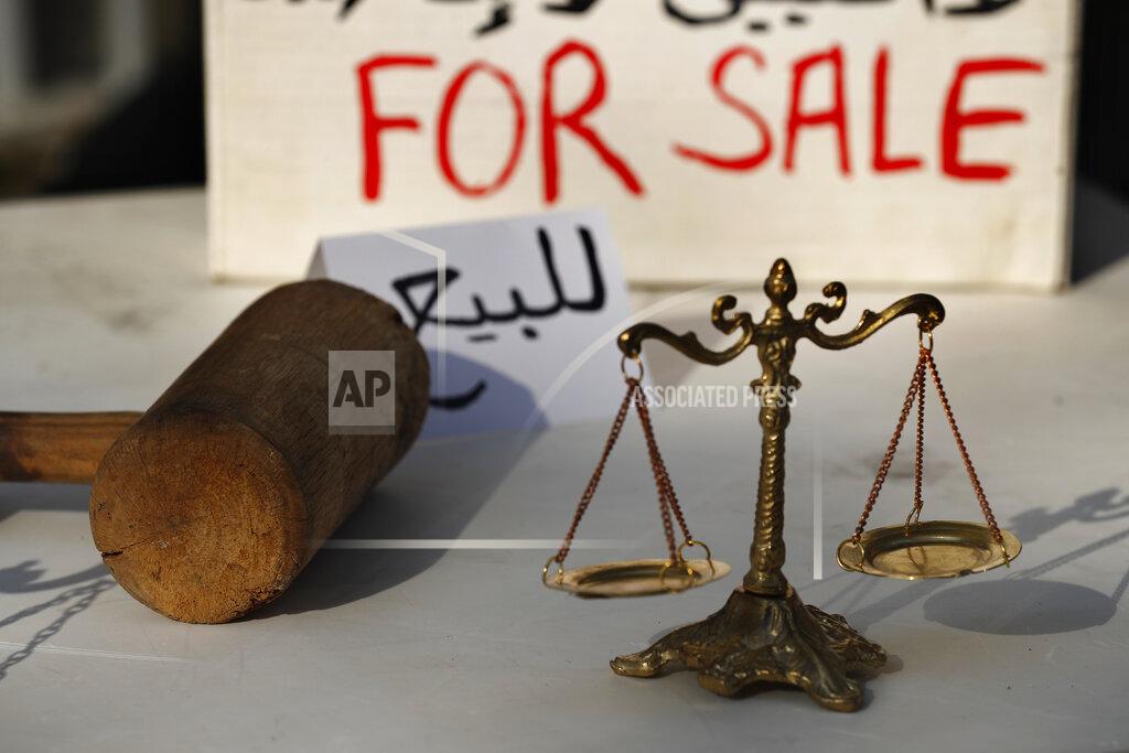 Hussein Malla FILE - In this Dec. 3, 2020 file photo, Lebanese activists display symbols of justice during a protest against the slow pace of the investigation into the August 4 explosion that hit Beirut's seaport, outside the Justice Palace, in Beirut. A public feud in recent weeks among prosecutors has starkly demonstrated how Lebanon's system of sectarian factions is paralyzing Lebanon's judicial system and snarling attempts to root out corruption. (AP Photo/Hussein Malla, File)