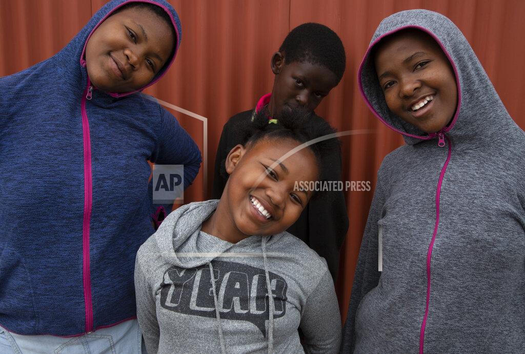 Denis Farrell Lilitha Jiphethu, 11, poses for a photo with her friends outside her home in Orange Farm, South Africa, on Tuesday, April 28, 2020. She prefers singing to drawing and chooses to sing a church song in her first language, Xhosa, as her way of describing the future after the pandemic. She misses her choir but takes comfort in the song’s lyrics. (AP Photo/Denis Farrell)