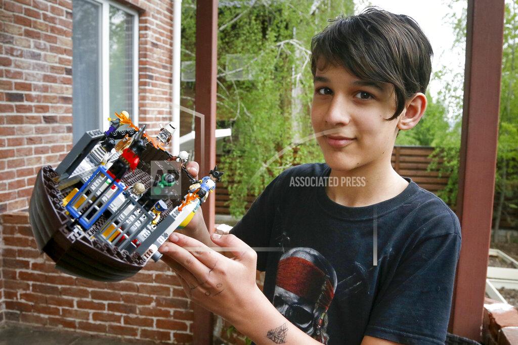 Efrem Lukatsky Danylo Boichuk, 12, shows his one of his LEGO constructions during an interview at his home in the village of Gorenichi outside Kyiv, Ukraine, on Tuesday, May 5, 2020. Ukraine has been under a COVID-19 coronavirus quarantine since March 12. Danylo envies his cat, Kari, who is able to escape from the family house and run free. Because of the pandemic, his family had to cancel a vacation in Bulgaria, and he worries a lot about closed borders. (AP Photo/Efrem Lukatsky)