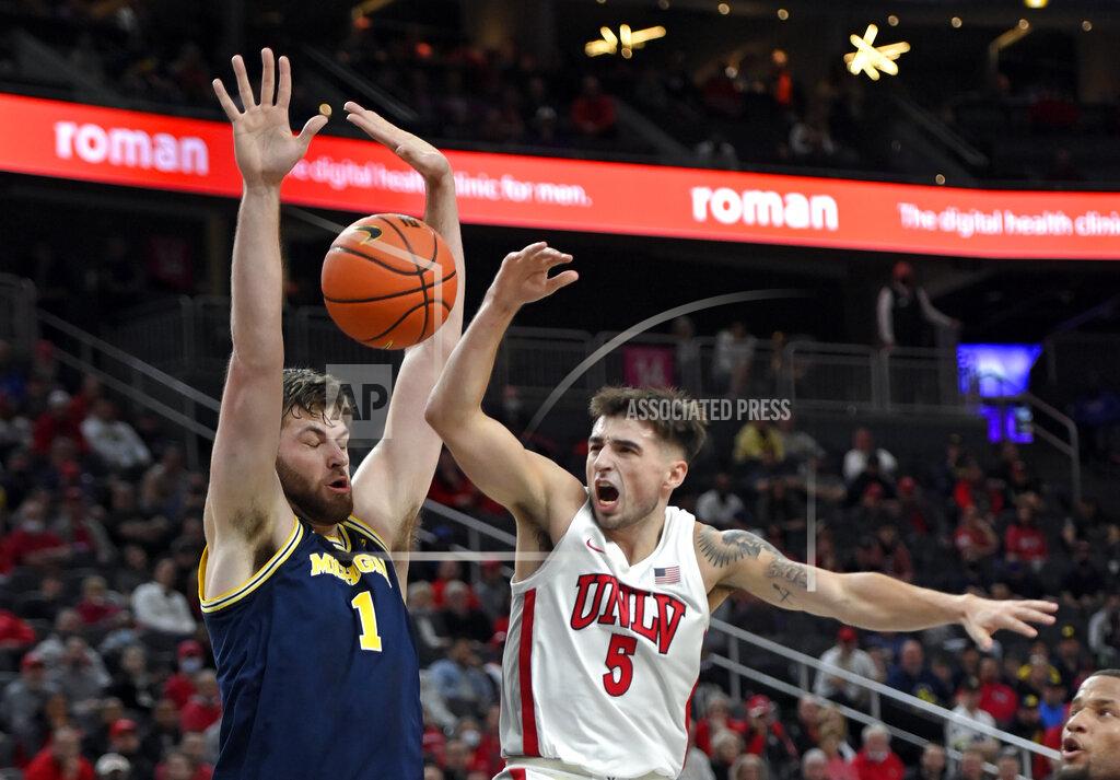 David Becker UNLV guard Jordan McCabe (5) loses the ball as he shoots against Michigan center Hunter Dickinson (1) during the first half of an NCAA college basketball game Friday, Nov. 19, 2021, in Las Vegas. (AP Photo/David Becker)