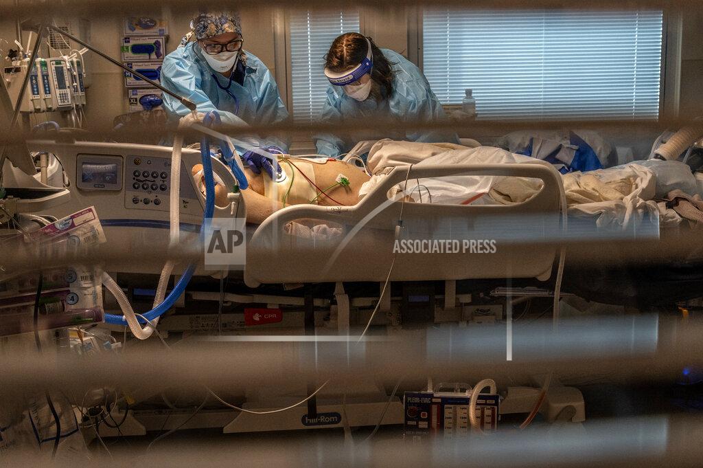 Renée C. Byer FILE - In this Dec. 22, 2020 file photo Phlebotomist lab assistant Jennifer Cukati, right, and Registered Nurse Carina Klescewski, left, care for a COVID-19 patient inside the Sutter Roseville Medical Center ICU in Roseville, Calif. California became the first state to record 2 million confirmed coronavirus cases, reaching the milestone on Christmas Eve as close to the entire state was under a strict stay-at-home order and hospitals were flooded with the largest crush of cases since the pandemic began. (Renee C. Byer/The Sacramento Bee via AP, Pool,File)