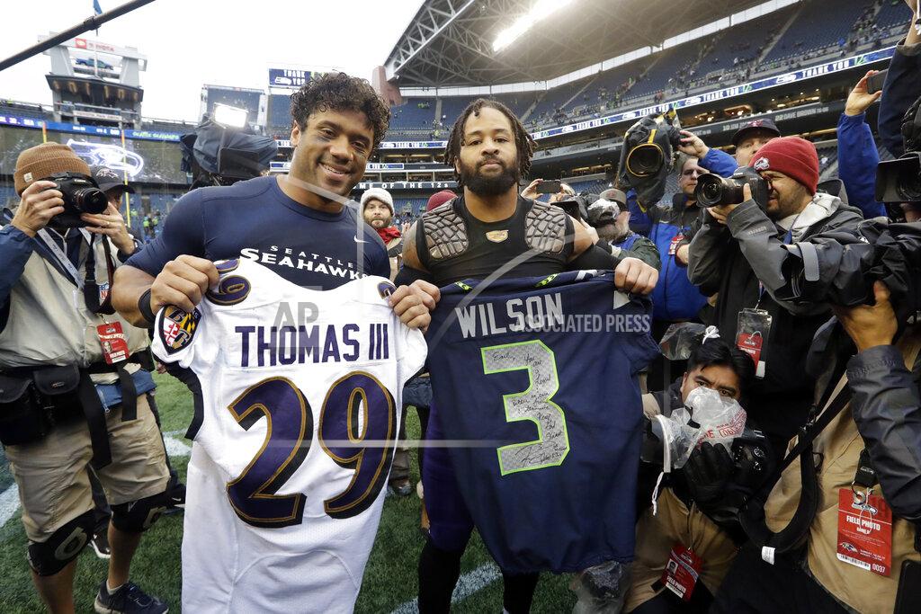 Elaine Thompson Seattle Seahawks quarterback Russell Wilson, left, and Baltimore Ravens free safety Earl Thomas, right, pose for a photo after they traded jerseys following an NFL football game, Sunday, Oct. 20, 2019, in Seattle. (AP Photo/Elaine Thompson)