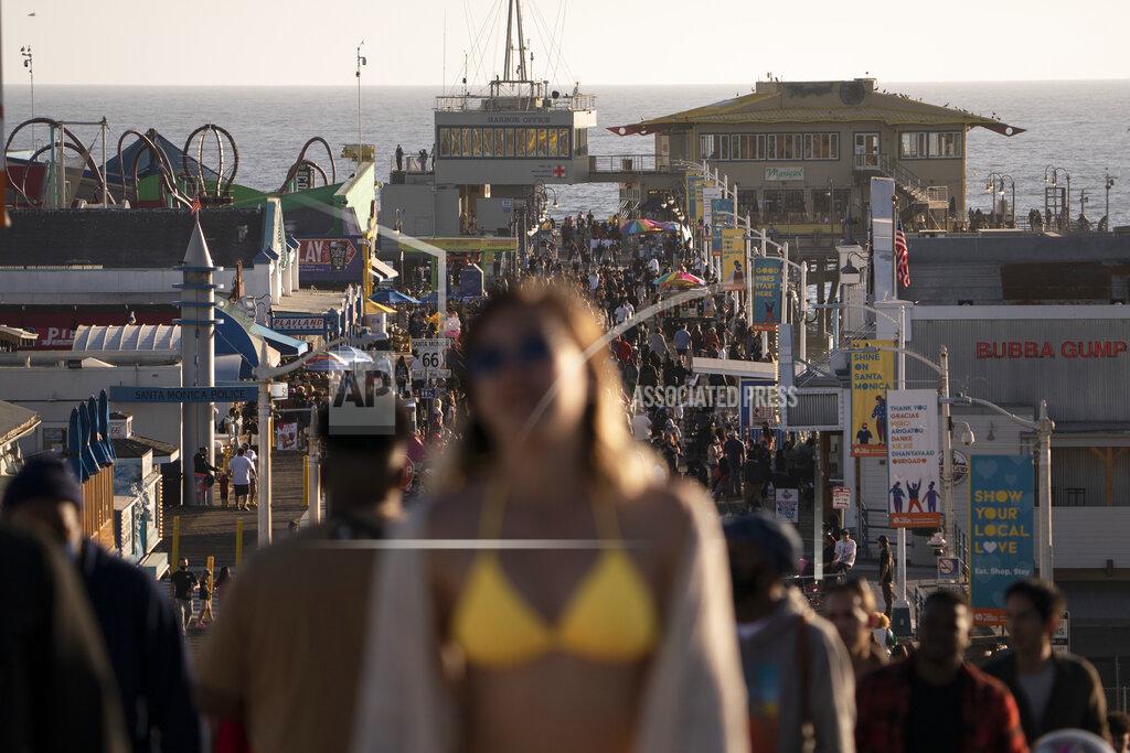 FILE - In this April 7, 2021, file photo, people crowd the Santa Monica Pier in Santa Monica, Calif. Teams of experts are projecting COVID-19's toll on the U.S. will fall sharply by the end of July, according to research released by the government Wednesday, May 5. (AP Photo/Jae C. Hong, File)