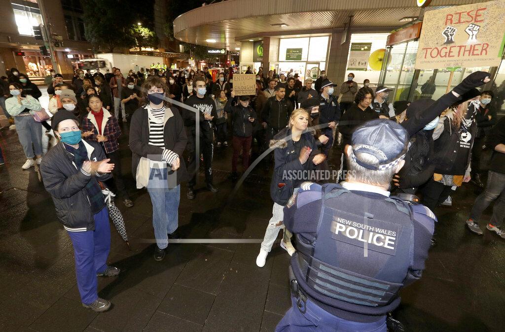 Rick Rycroft Police watch protesters that gathered in Sydney, Friday, June 12, 2020, to support U.S. protests over the death of George Floyd. Hundreds of police disrupted plans for a Black Lives Matter rally but protest organizers have vowed that other rallies will continue around Australia over the weekend despite warnings of the pandemic risk. (AP Photo/Rick Rycroft)