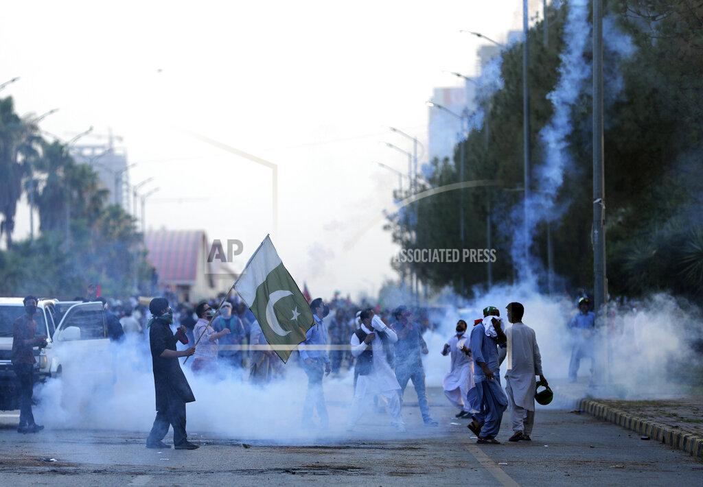 Rahmat Gul Police fire tear gas to disperse supporters of Pakistan's key opposition party, in Islamabad, Pakistan, Wednesday, May 25, 2022. Pakistani authorities blocked off all major roads into the capital Islamabad on Wednesday, after a defiant former Prime Minister Imran Khan said he would march with demonstrators to the city center for a rally he hopes will bring down the government and force early elections. (AP Photo/Rahmat Gul)