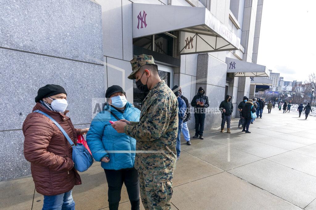 Mary Altaffer FILE - In this Feb. 5, 2021, file photo, a National Guardsman helps people standing in line to register for an appointment for their first dose of the COVID-19 vaccine at a vaccination site at Yankee Stadium in the Bronx borough of New York. More than 1 million COVID-19 vaccination shots have been given at Major League Baseball stadiums, with the Oakland Coliseum and Marlins Park among the sites planning to continue operating after opening day. The 11 ballparks that converted to mass vaccination centers in the offseason combined to pass a million total shots this week, MLB said Friday, March 26. (AP Photo/Mary Altaffer, File)
