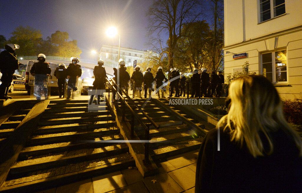 Czarek Sokolowski Police stand guard while protesters block the parliament in Warsaw, Poland, Wednesday Oct. 28, 2020. People across Poland stayed off their jobs and huge crowds poured onto the streets for a seventh straight day of protests Wednesday, enraged over a top court ruling that bans abortions in cases of fetal abnormalities. (AP Photo/Czarek Sokolowski)