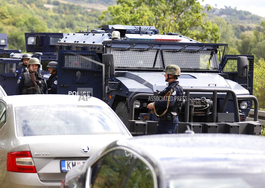 Bojan Slavkovic Kosovo special police with armored vehicles stand on the road near the northern Kosovo border crossing of Jarinje, Monday, Sept. 20, 2021. Tensions soared Monday at the border between Kosovo and Serbia as Kosovo deployed additional police to implement a rule to remove Serbian license plates from cars entering Kosovo, while Serbs protested the move. (AP Photo/Bojan Slavkovic)