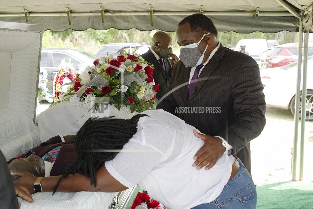 Allen G. Breed Funeral director Shawn Troy comforts a distraught mourner during a graveside service at Hillcrest Cemetery outside Mullins, S.C., on Monday, May 24, 2021. His father, William Penn Troy Sr., died of COVID-19 in August 2020, one of many Black funeral directors to succumb during the pandemic. (AP Photo/Allen G. Breed)