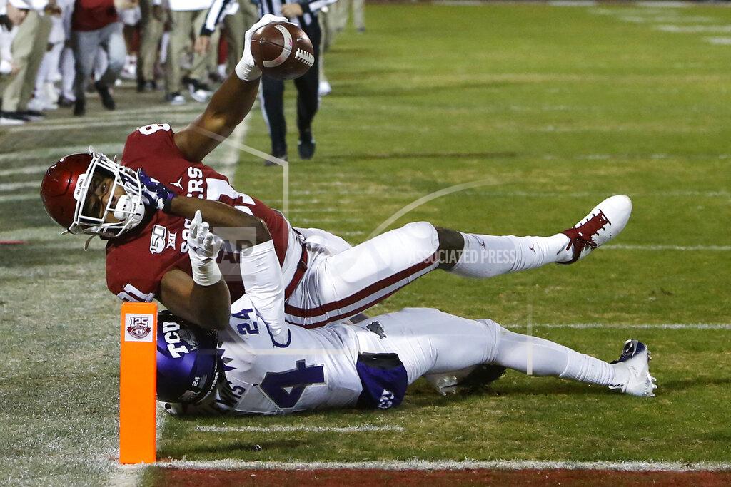 Sue Ogrocki Oklahoma fullback Brayden Willis (81) reaches the ball into the end zone for a touchdown as he is tackled by TCU cornerback Julius Lewis (24) in the first half of an NCAA college football game in Norman, Okla., Saturday, Nov. 23, 2019. (AP Photo/Sue Ogrocki)