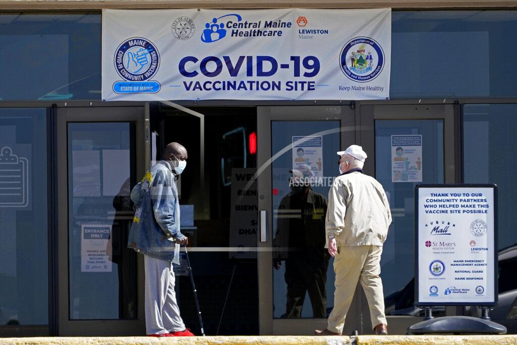 Robert F. Bukaty FILE - In this May 12, 2021, file photo, one man holds the door for another as they arrive at a COVID-19 vaccination clinic at the Auburn Mall in Auburn, Maine. As cases fall and states reopen, the potential final stage in the U.S. campaign to vanquish COVID-19 is turning into a slog, with a worrisome variant gaining a bigger foothold and lotteries and other inducements failing to persuade some Americans to get vaccinated. Maine and other states are convening focus groups to better understand who is declining to get vaccinated, why, and how they could be persuaded that vaccinating is the right choice. (AP Photo/Robert F. Bukaty)