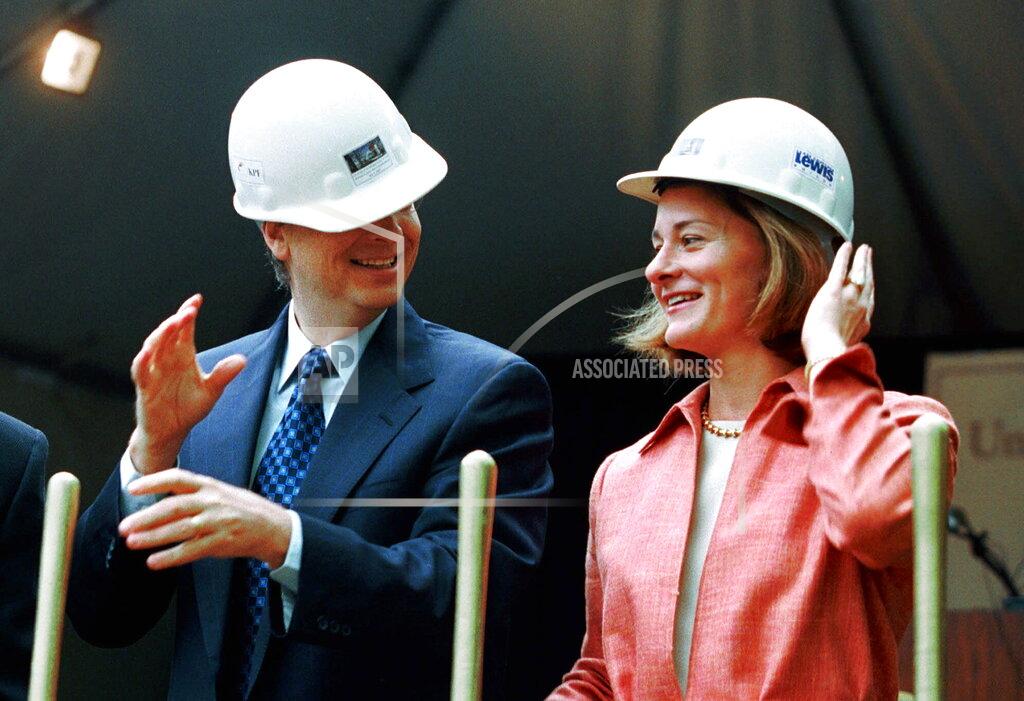 Andy Rogers FILE - In this May 4, 2001, file photo, Microsoft Chairman Bill Gates contends with an ill-fitting hard hat while his wife, Melinda Gates, looks on in Seattle at the groundbreaking of the University of Washington's new law school facility, William H. Gates Hall. The couple announced Monday, May 3, 2021, that they are divorcing. (AP Photo/Andy Rogers, File)