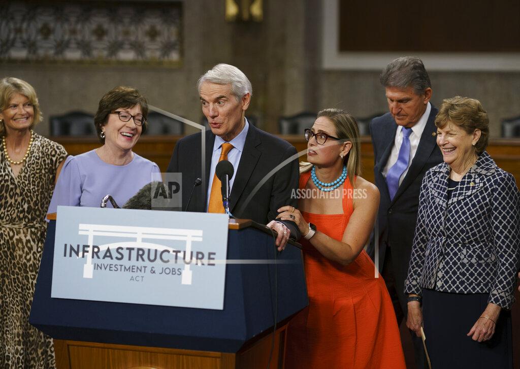 J. Scott Applewhite The bipartisan group of Senate negotiators speak to reporters just after a vote to start work on a nearly $1 trillion bipartisan infrastructure package, at the Capitol in Washington, Wednesday, July 28, 2021. From left are Sen. Lisa Murkowski, R-Alaska, Sen. Susan Collins, R-Maine, Sen. Rob Portman, R-Ohio, Sen. Kyrsten Sinema, D-Ariz., Sen. Joe Manchin, D-W.Va., and Sen. Jeanne Shaheen, D-N.H., (AP Photo/J. Scott Applewhite)