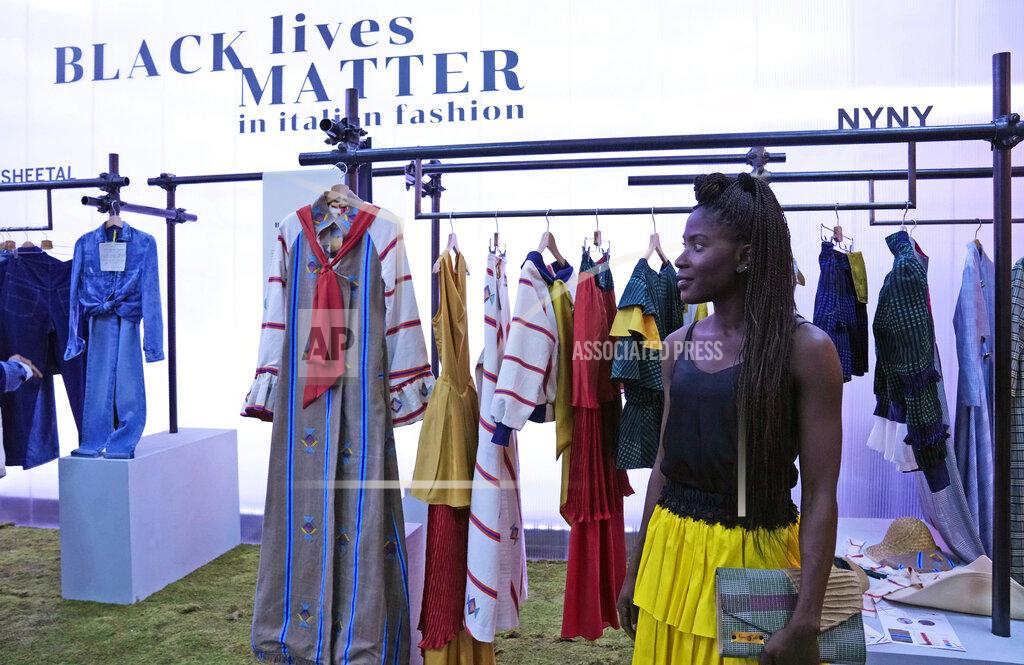 Antonio Calanni Fashion designer Fallylah Nyny Ryke Goungou, from Togo, poses in front her creations, part of the Black Lives Matter Spring Summer 2022 collective fashion event, unveiled during the Milan Fashion Week, in Milan, Italy, Tuesday, Sept. 21, 2021. (AP Photo/Antonio Calanni)