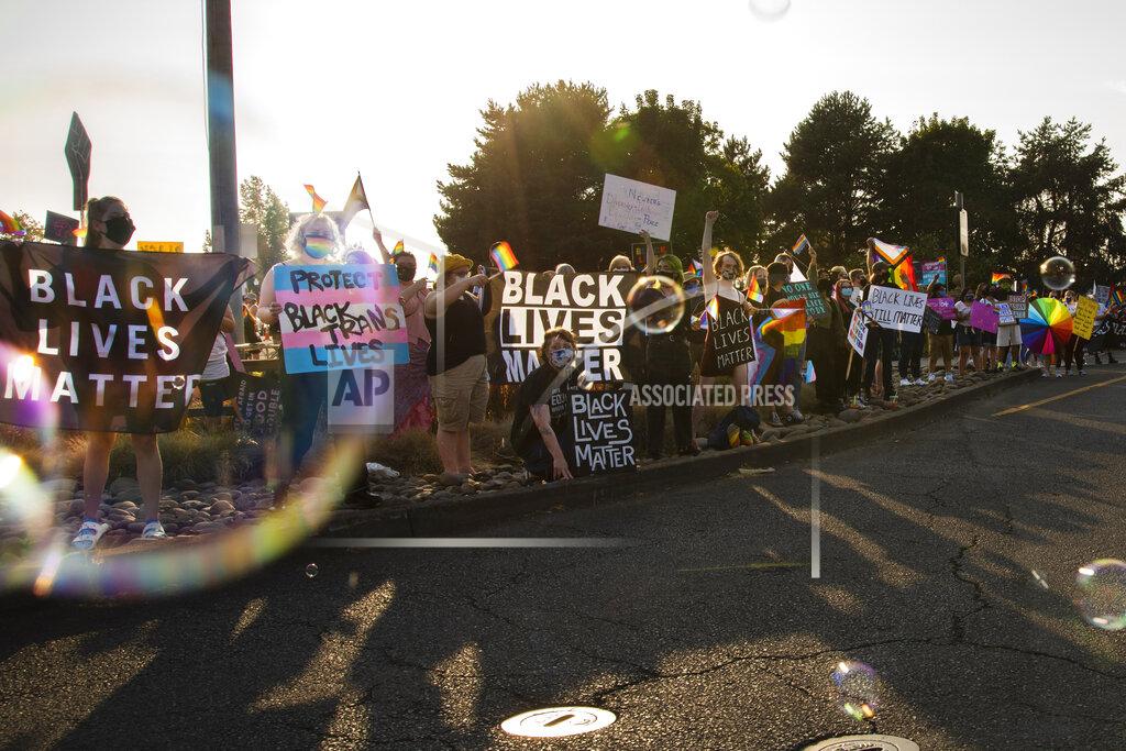 Jozie Donaghey Protesters against a new school policy that bans Black Lives Matter and Pride flags across Newberg School District facilities wave at cars entering and leaving Newberg, Ore., on Aug. 24, 2021. The policy has prompted a torrent of recriminations and threats to boycott the town and its businesses. (Jozie Donaghey/The Oregonian via AP)