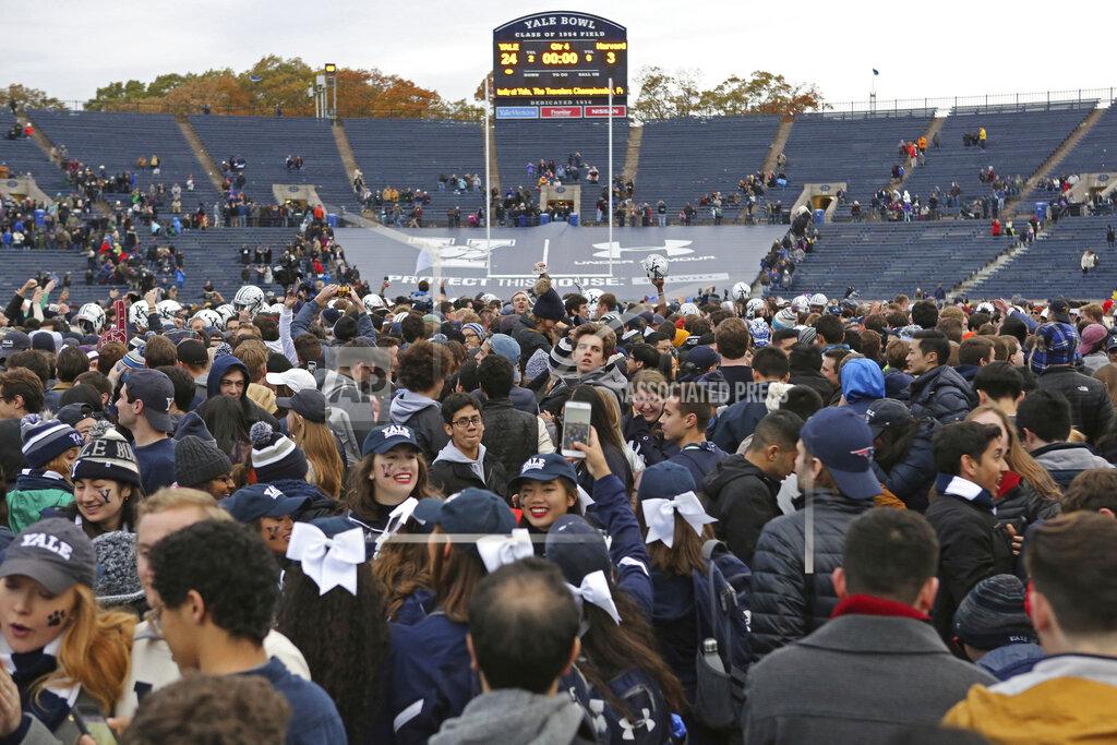 FILE - In this Nov. 18, 2017, file photo, Yale students rush the field after Yale defeated Harvard in an NCAA college football game in New Haven, Conn. As they return, players will face new protocols to combat the spread of the delta variant. (AP Photo/Gregory Payan, File)