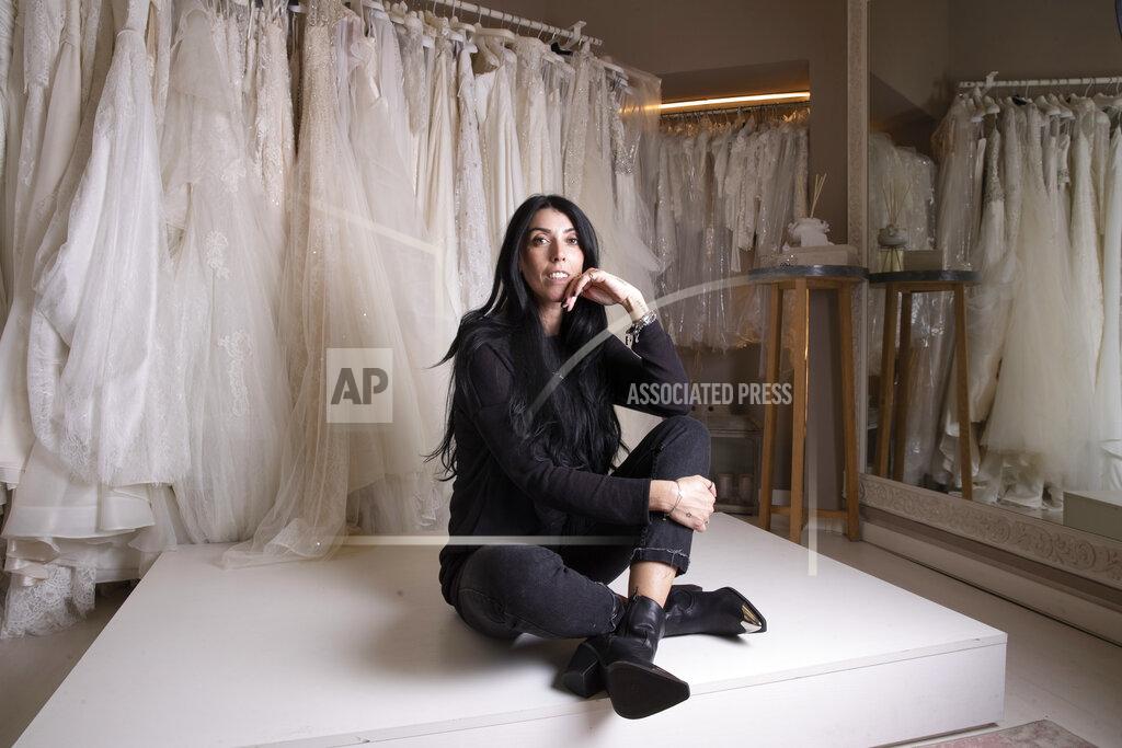 Alessandra Tarantino Anita Galafate poses in a wedding dress shop in Rome, Tuesday March 9, 2021. Self-employed wedding planner Anita Galafate, 38, saw nearly all her business evaporate in the pandemic. Worldwide, working women paid a high price during the pandemic as many quit jobs to care for children when schools closed. But Italy's women went into the crisis already struggling for decades to expand their presence in the national workforce. Among the 27 European Union nations, Italian women rank next to the bottom, after Greek women, in terms of percentage in national workforces. Among young women, Italians rank the lowest. (AP Photo/Alessandra Tarantino)